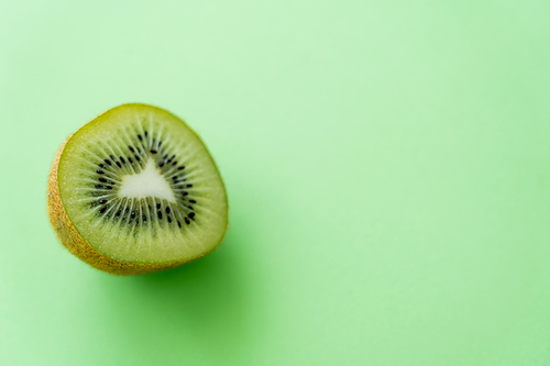 top view of kiwi fruit half on green