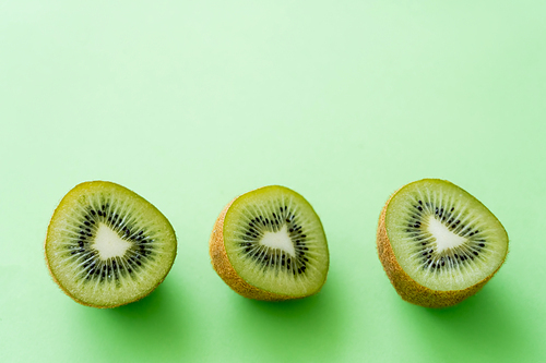 top view of kiwi fruit halves on green