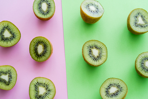 flat lay of organic kiwi fruit on green and pink