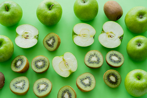 flat lay of ripe apples and kiwi fruits on green