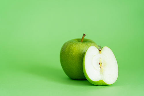 organic and fresh apples on green background