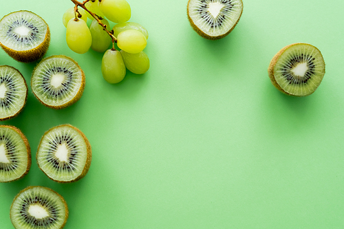 top view of kiwi fruit near grapes on green