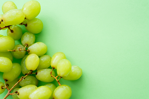 top view of ripe and organic grapes on green