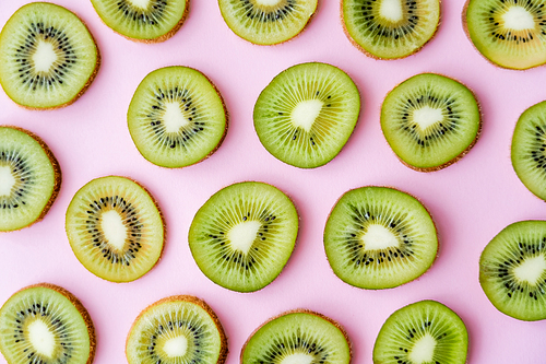 top view of sliced fresh kiwi on pink