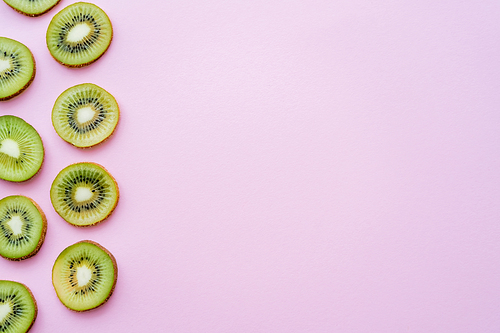 top view of sliced juicy kiwi on pink with copy space