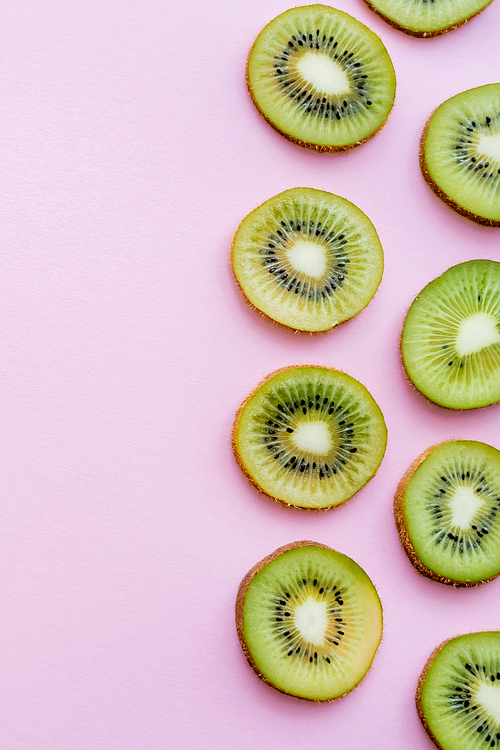 top view of sliced organic kiwi on pink