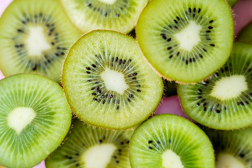 top view of sliced fresh kiwi on pink, close up