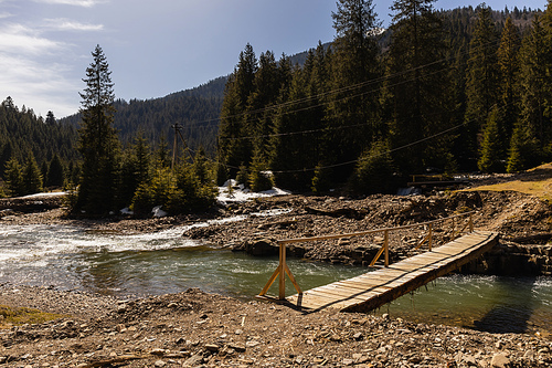 Wooden bridge above river in mountains