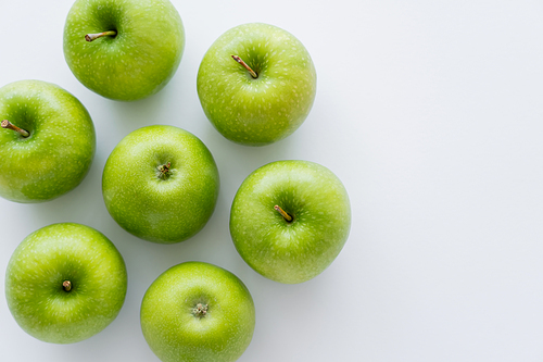 top view of whole green apples on white with copy space