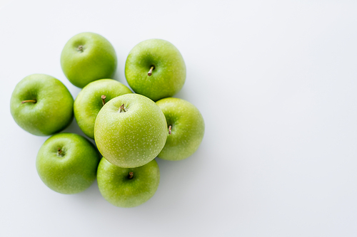 top view of green and fresh pile of apples on white