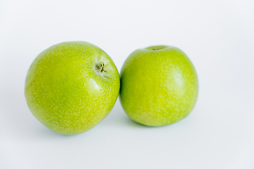 green and ripe apples on white