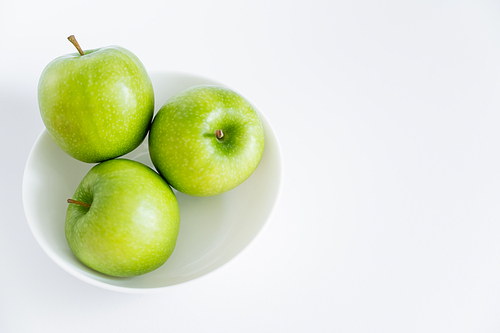 top view of green and ripe apples in bowl on white