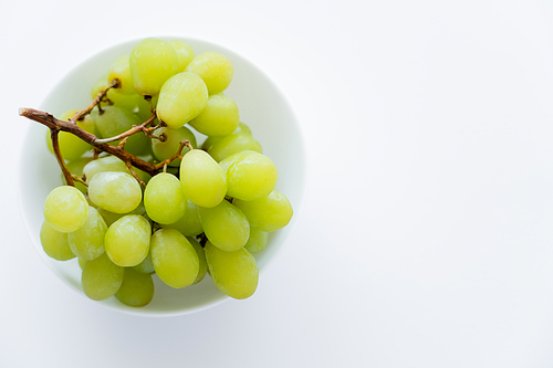 top view of green grapes in bowl on white