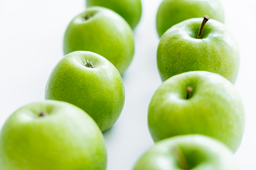 rows of green and fresh apples on white