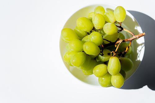 top view of tasty green grapes in bowl on white