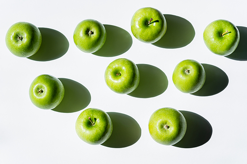 top view of shadows near ripe apples on white