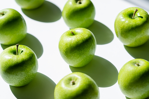 close up of green tasty apples on white