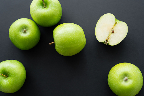 top view of juicy and green apples on black