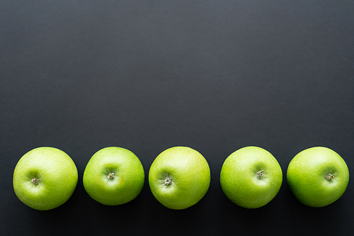 top view of fresh and green apples in row on black