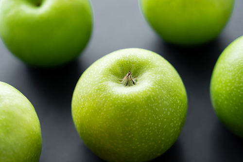 close up view of green ripe apples on black