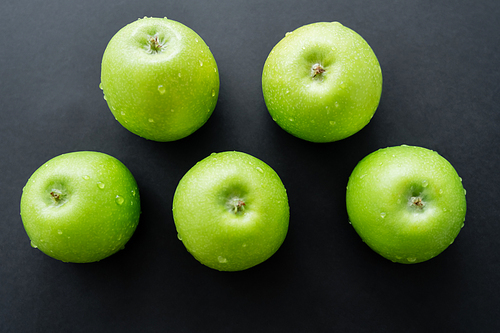 flat lay of green and fresh apples with water drops on black