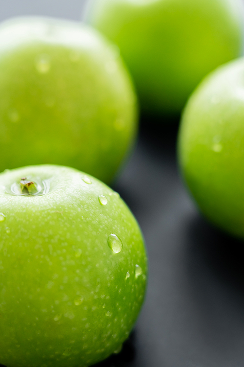 close up view of fresh apples with water drops on black