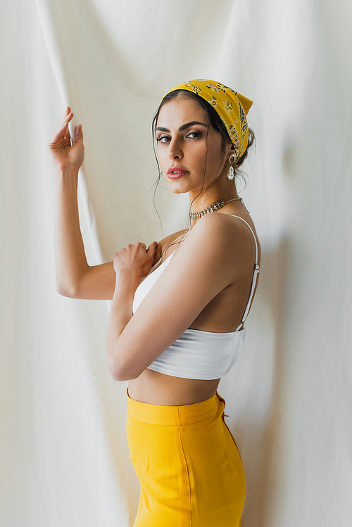 woman in yellow headscarf and crop top  on white