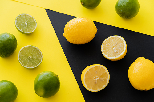 Top view of fresh lemons on black and limes on yellow background