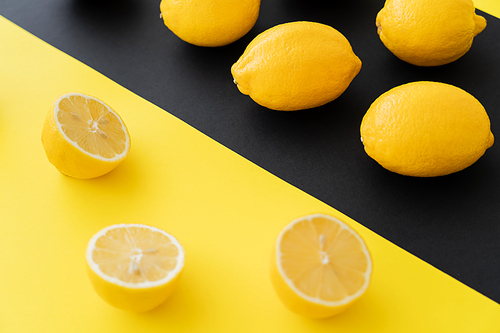 Whole and cup lemons on black and yellow background