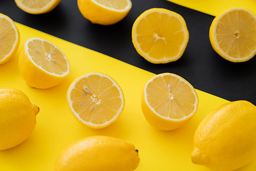 Close up view of organic lemons on black and yellow background
