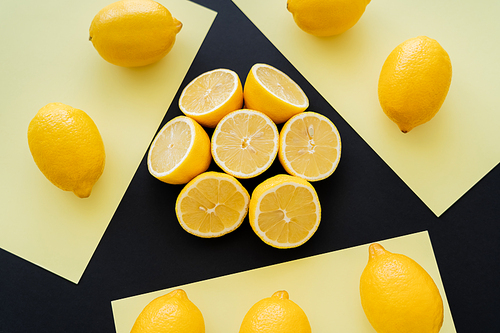 Flat lay with round of cut lemons on beige and black background
