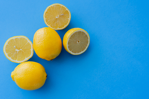 Top view of juicy lemons on blue background