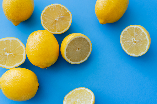 Top view of fresh bright lemons on blue background