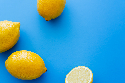 Top view of fresh lemons on blue background with copy space
