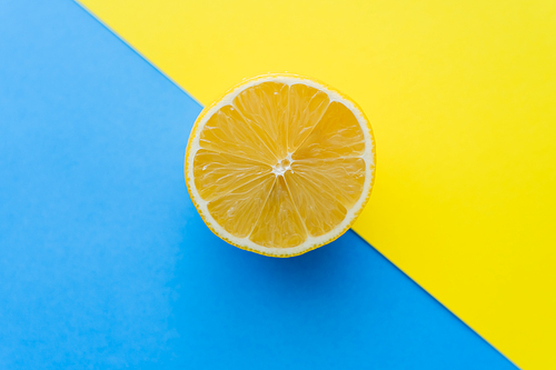 Top view of cut lemon on blue and yellow background