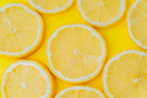 Top view of sliced lemon on yellow background