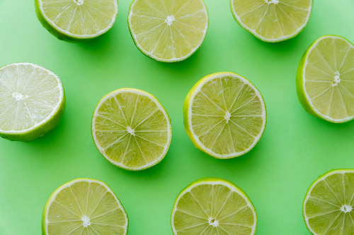 Top view of cut limes on green background