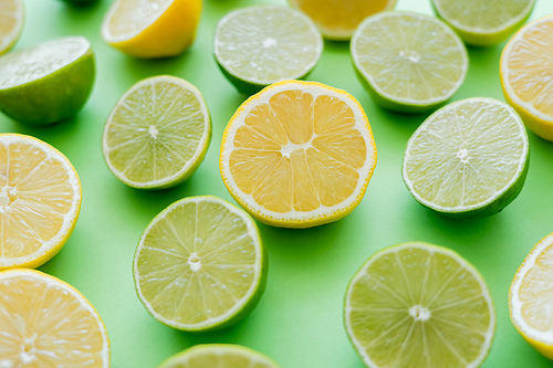 Close up view of cut and juicy citrus fruits on green background