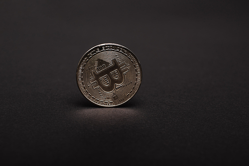 KYIV, UKRAINE - APRIL 26, 2022: Close up view of silver crypto coin on black background