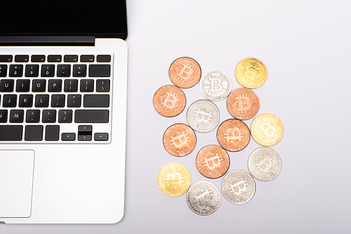 KYIV, UKRAINE - APRIL 26, 2022: Top view of laptop and cryptocurrency on white background