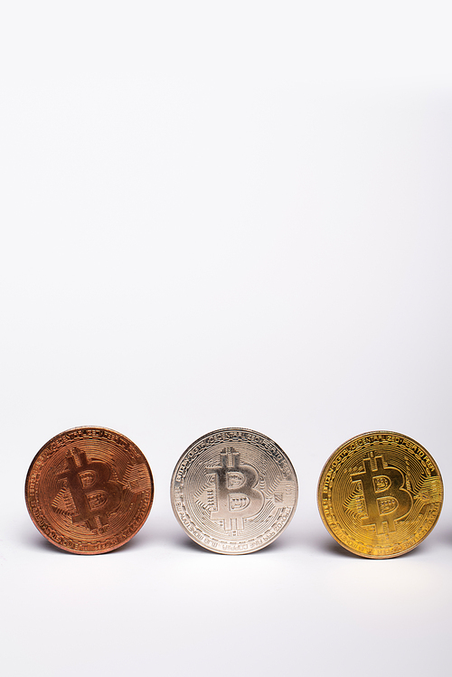 KYIV, UKRAINE - APRIL 26, 2022: Close up view of different bitcoins on white background with copy space