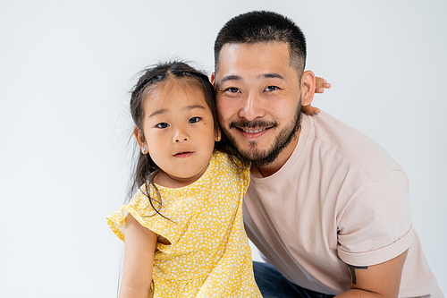 portrait of asian girl hugging happy father isolated on grey