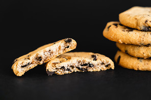 Close up view of tasty cookies with chocolate chips on black background
