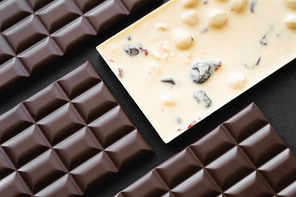 Top view of white and dark chocolate bars on black background