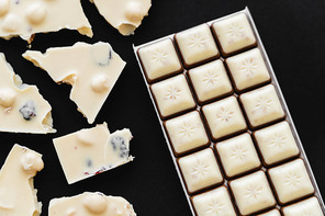 Top view of tasty white chocolate on black background