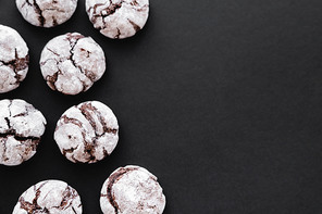 Top view of cookies with powdered sugar on black background