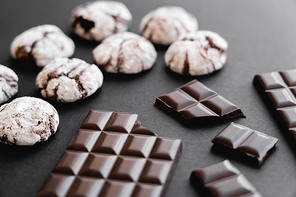 Close up view of chocolate bars and biscuits on black background