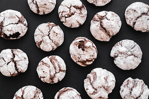 Top view of biscuits with powdered sugar on black background