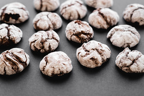 Close up view of delicious cookies with powdered sugar on black background