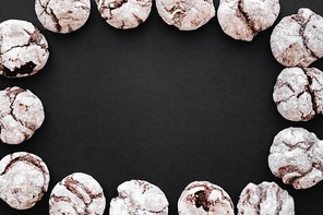 Top view of frame from biscuits with powdered sugar on black background